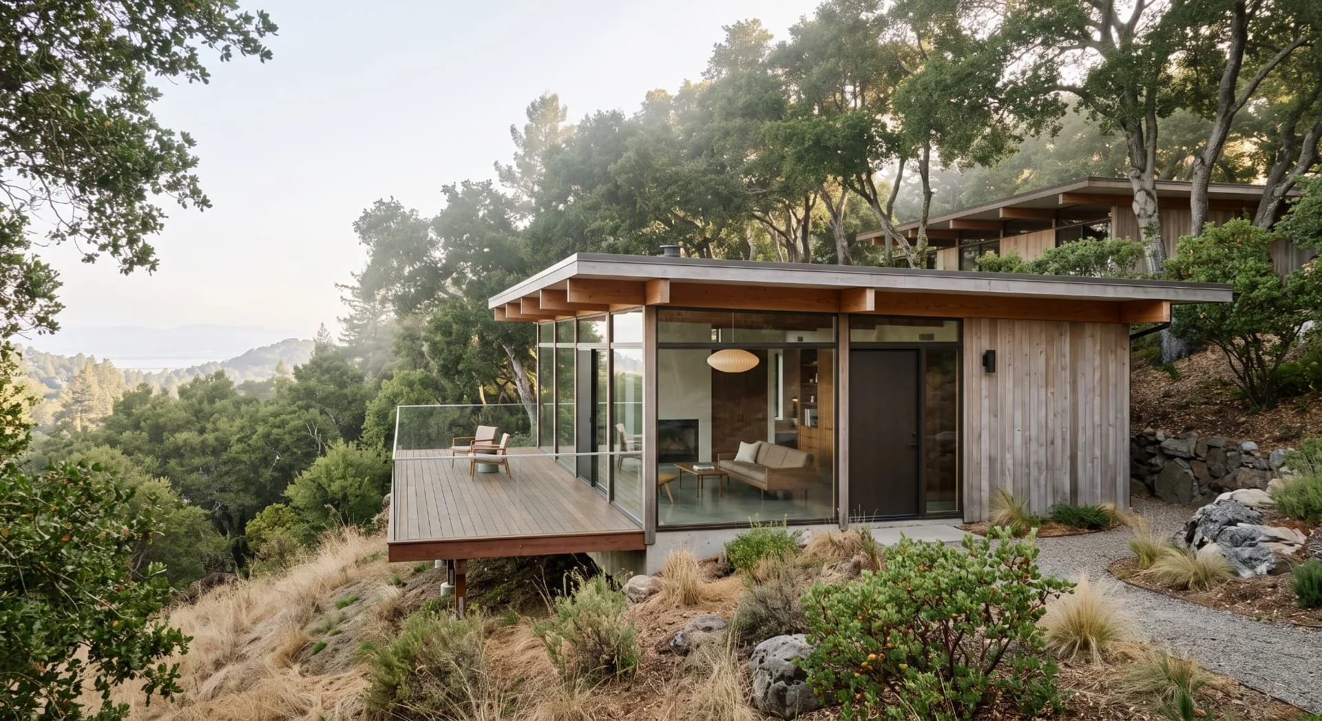 Modern wood-clad ADU with a cantilevered deck on a wooded Ladera hillside