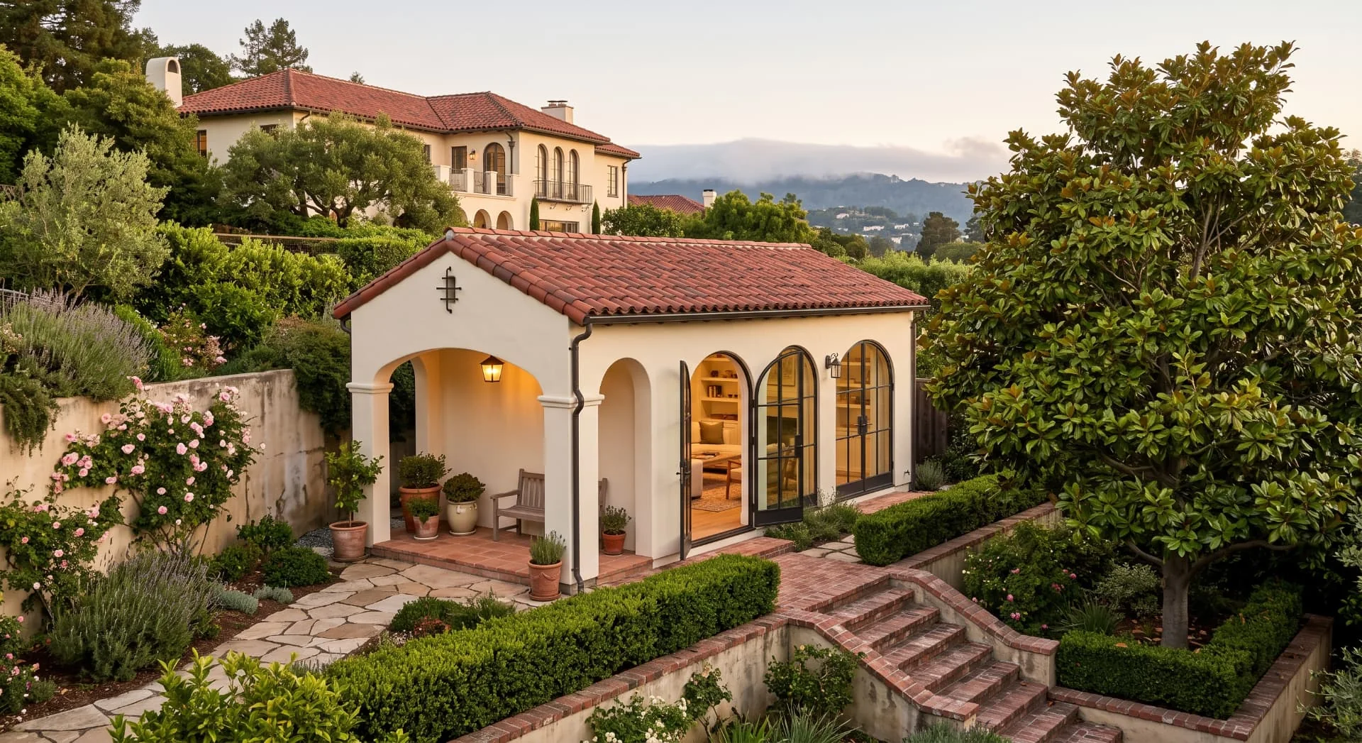 Spanish-style ADU with a tile roof and arched steel doors in a Piedmont garden